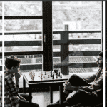 Imagen de Pinterest de un padre y un hijo preadolescente jugando al ajedrez en la sala de un aeropuerto antes de viajar