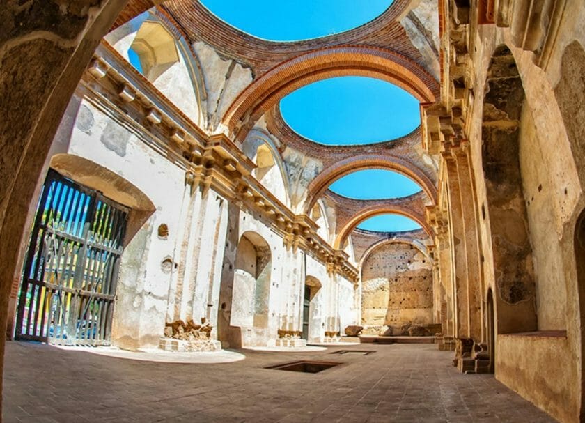 Muestra el cielo azul y el sol brillando a través del techo de la Catedral de San José en Antigua, Cosas que hacer en Antigua Guatemala