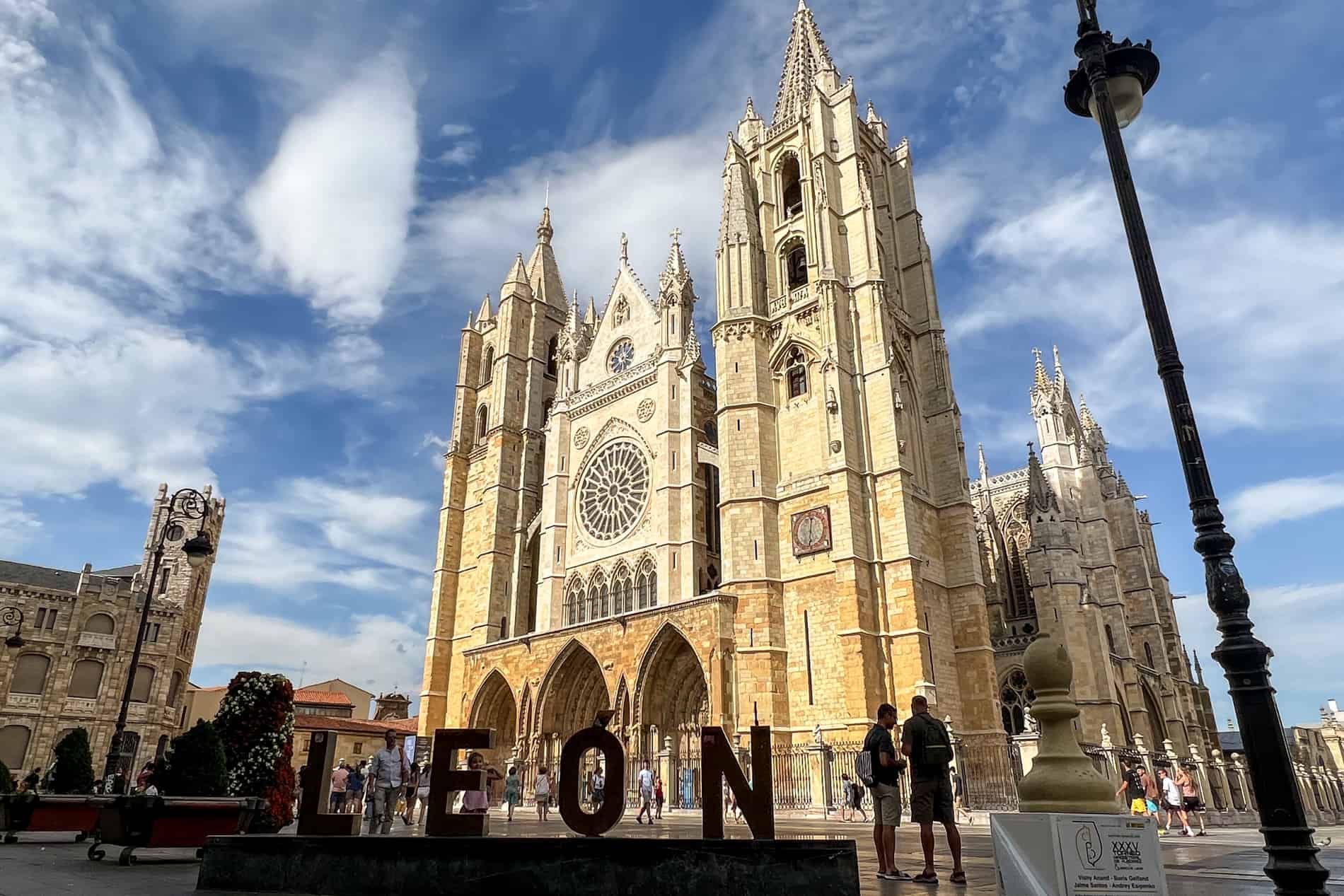 Un letrero de bronce de León en la plaza frente a la magnífica estructura gótica dorada de la Catedral de León.
