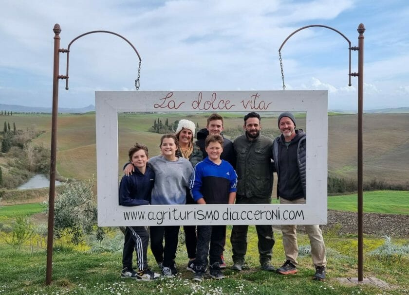 Foto de la familia con un cartel para agriturismo Diaccenroni, Cosas que hacer en la Toscana